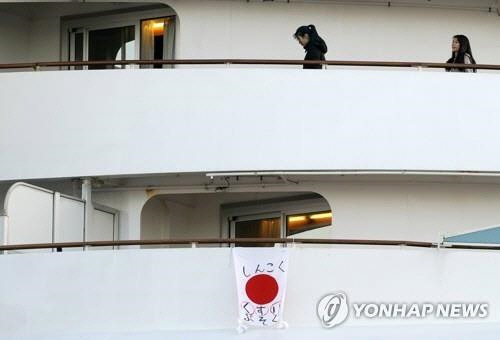 우한 폐렴 감염자가 집단으로 발생한 일본 크루즈선 '다이아몬드 프린세스'에 지난 7일 의약품 부족이 심각하다는 메시지를 적은 일장기가 걸려 있다.  [요코하마=epa 연합뉴스]